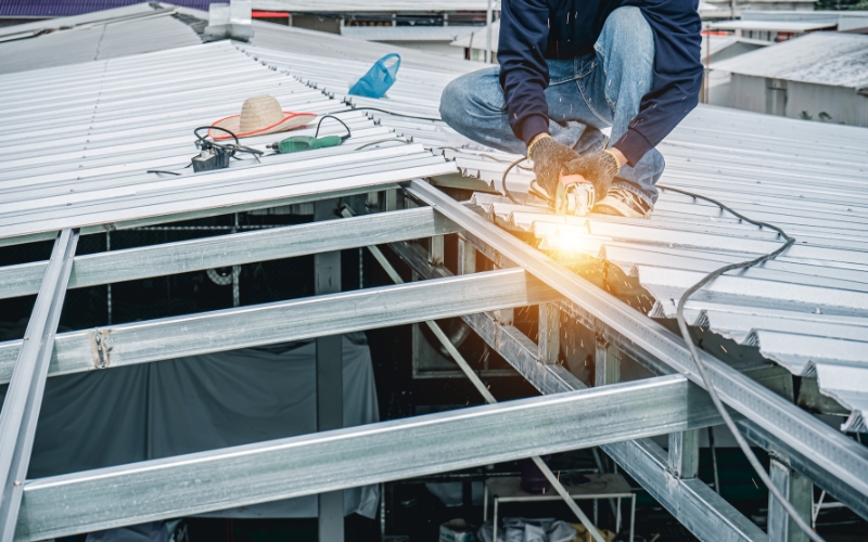 Ouvrier installant une toiture plate en bac acier