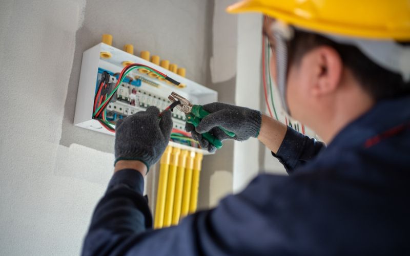 Électricien installant câbles et équipements électriques dans un bâtiment Paris